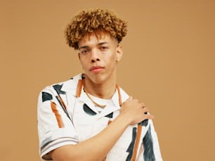 a young man with curly hair wearing a white shirt