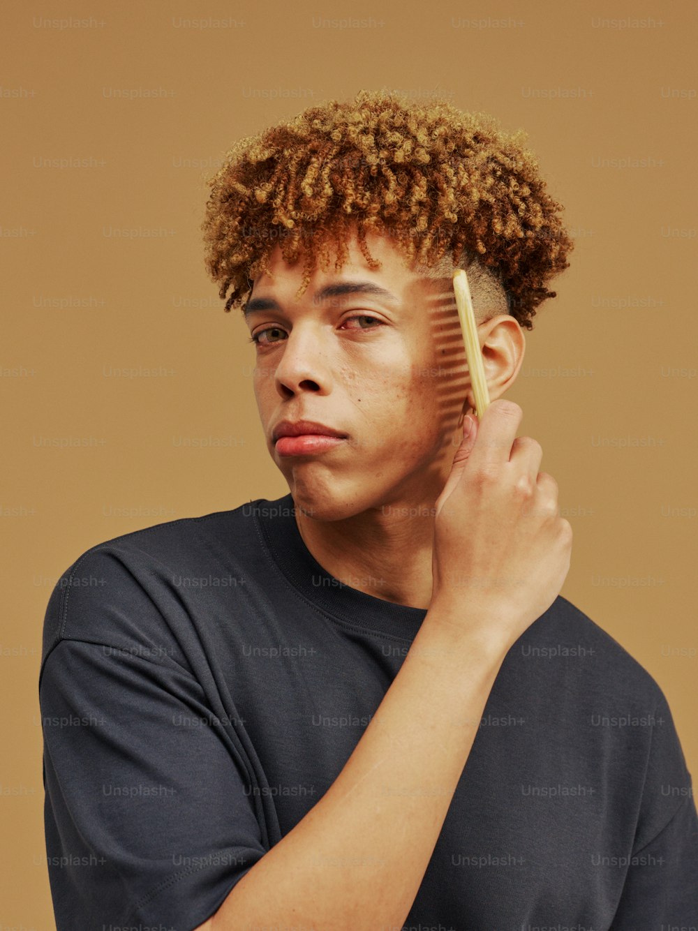 a young man is combing his hair with a comb