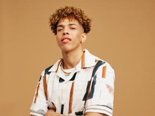 a young man with curly hair wearing a striped shirt
