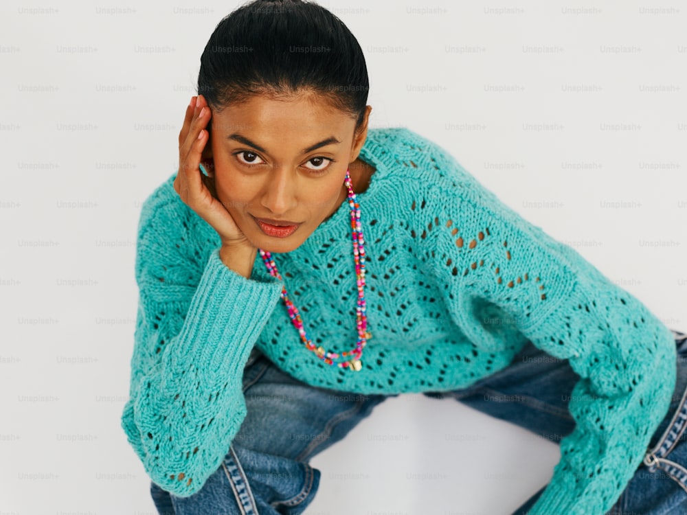 Eine Frau in blauem Pullover und Jeans posiert für ein Foto