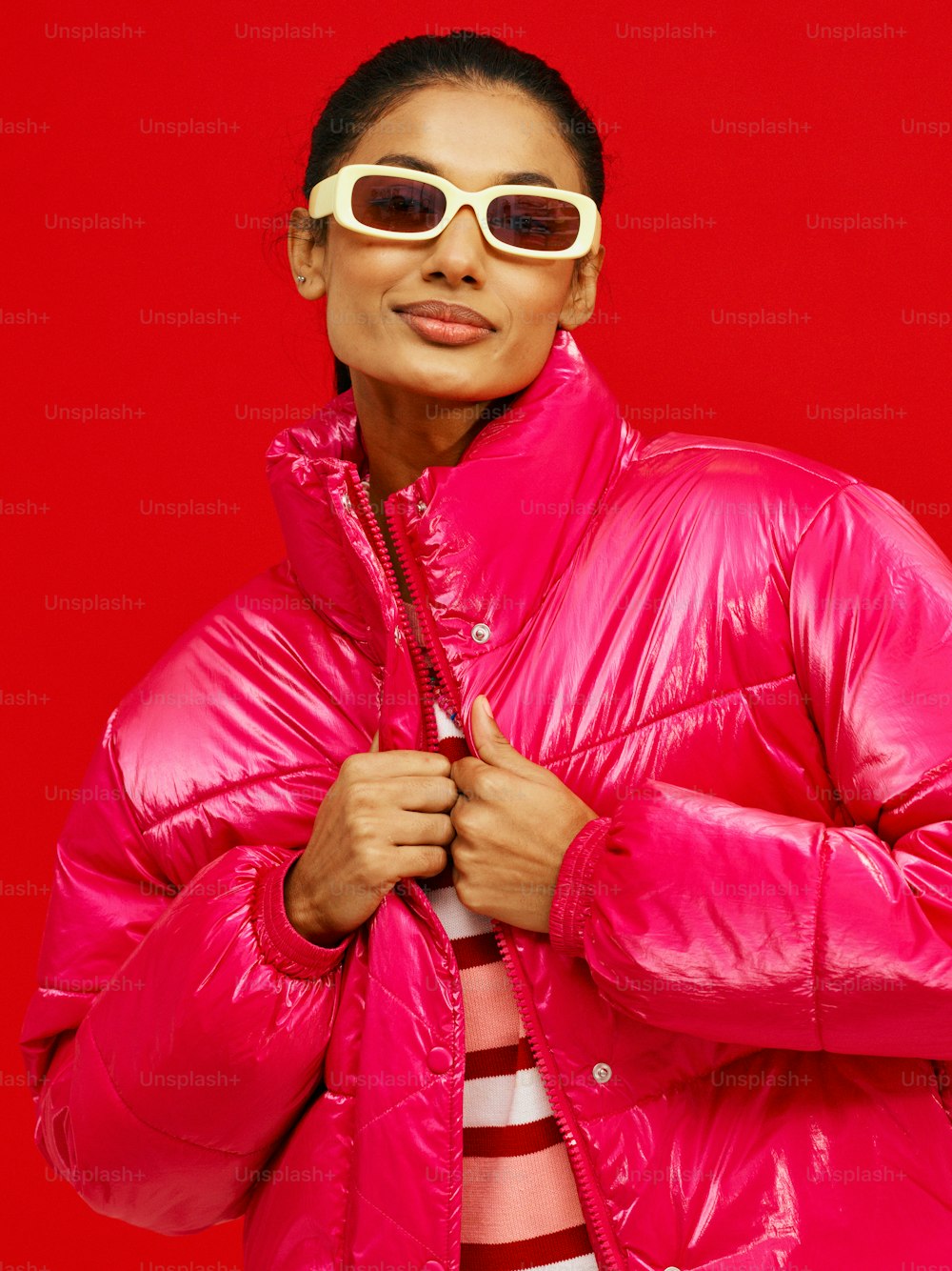 a woman in a pink jacket and sunglasses