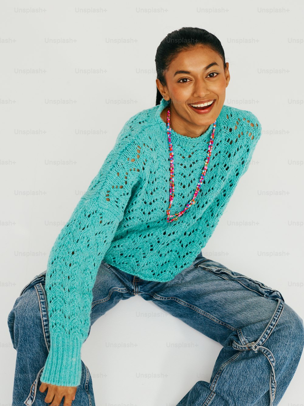 a woman in a blue sweater and jeans posing for a picture