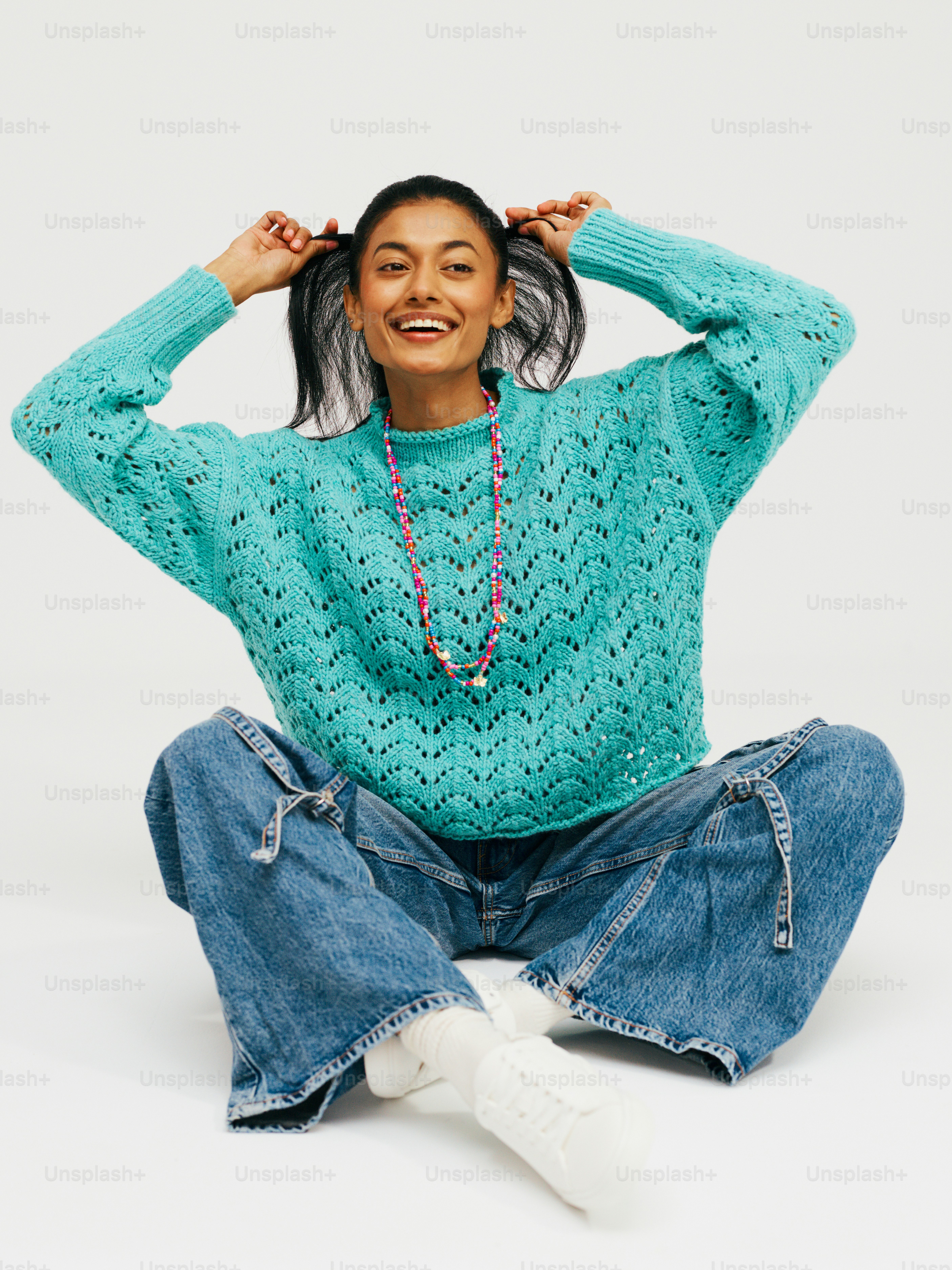 a woman sitting on the floor with her hands on her head