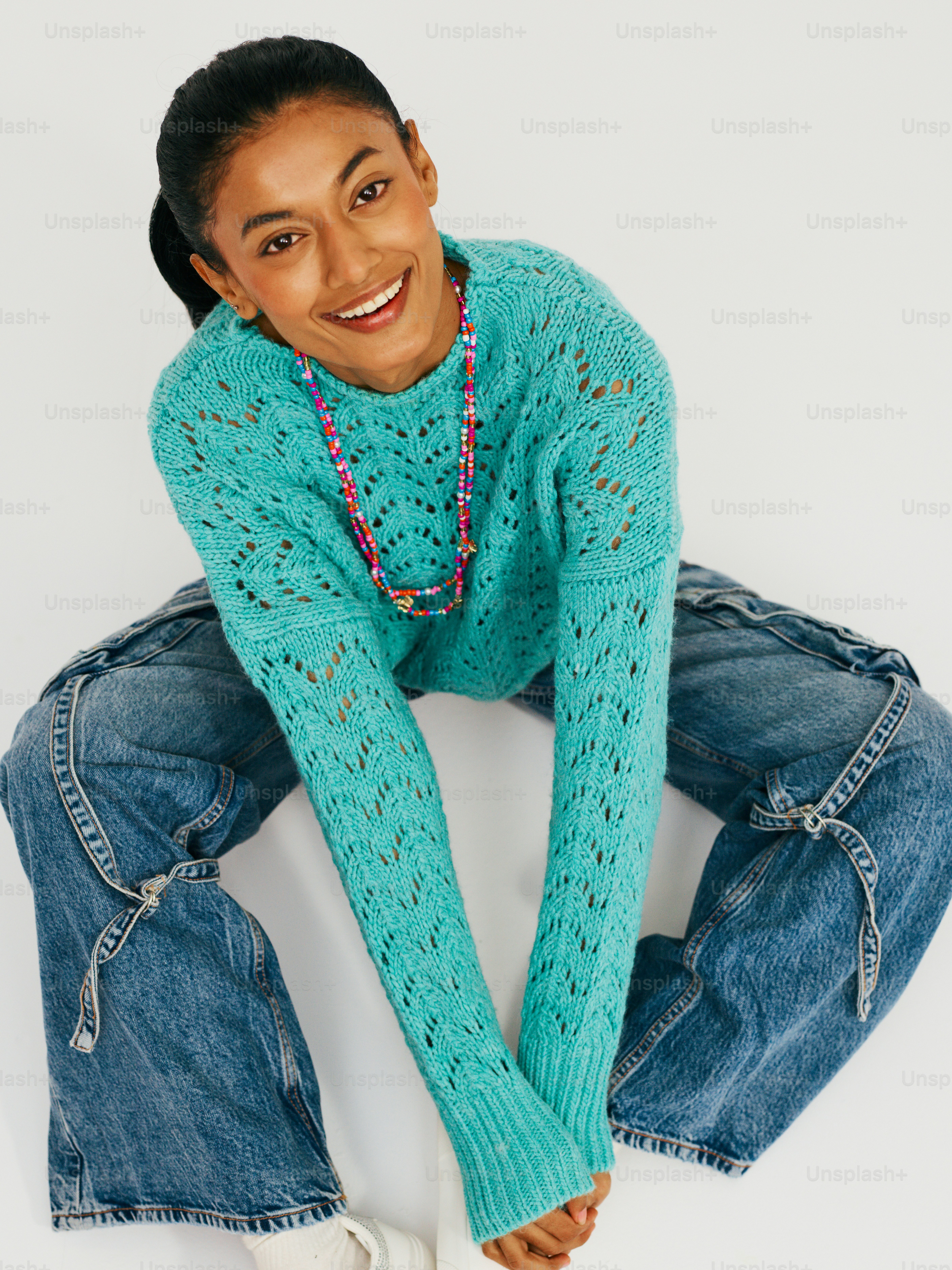 Eine Frau in blauem Pullover und Jeans posiert für ein Foto