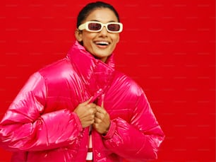 una mujer con una chaqueta rosa brillante y gafas de sol