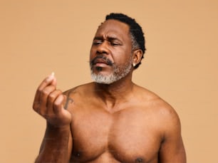 a shirtless man with a cigarette in his hand