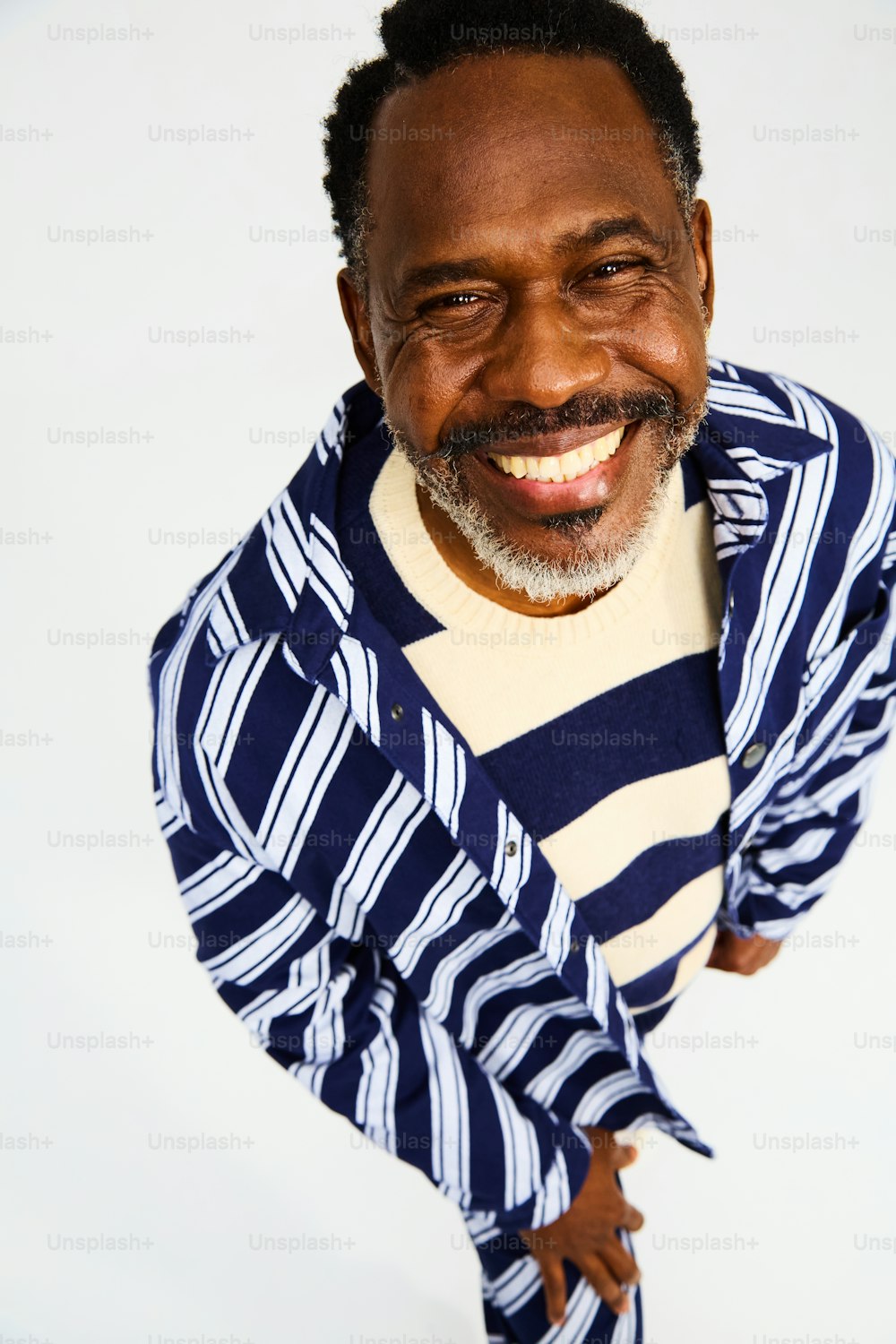 un hombre sonriente con camisa y corbata a rayas
