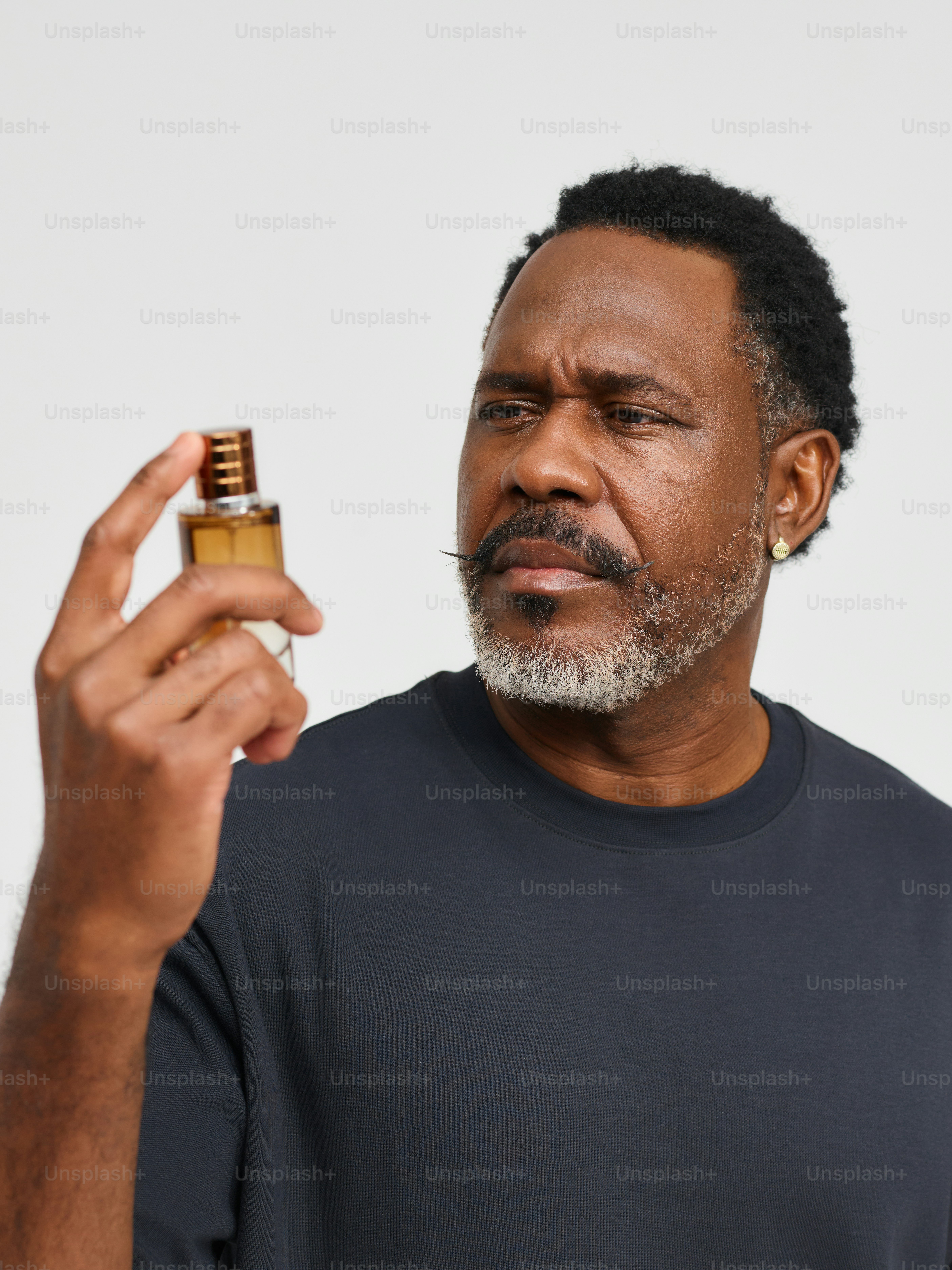 a man holding a bottle of perfume in his hand