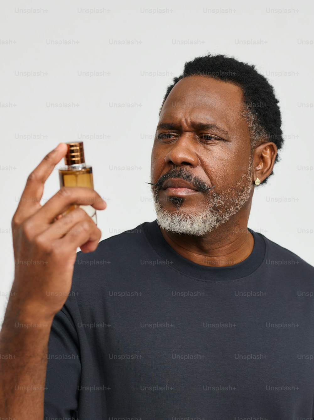 um homem segurando um frasco de perfume na mão