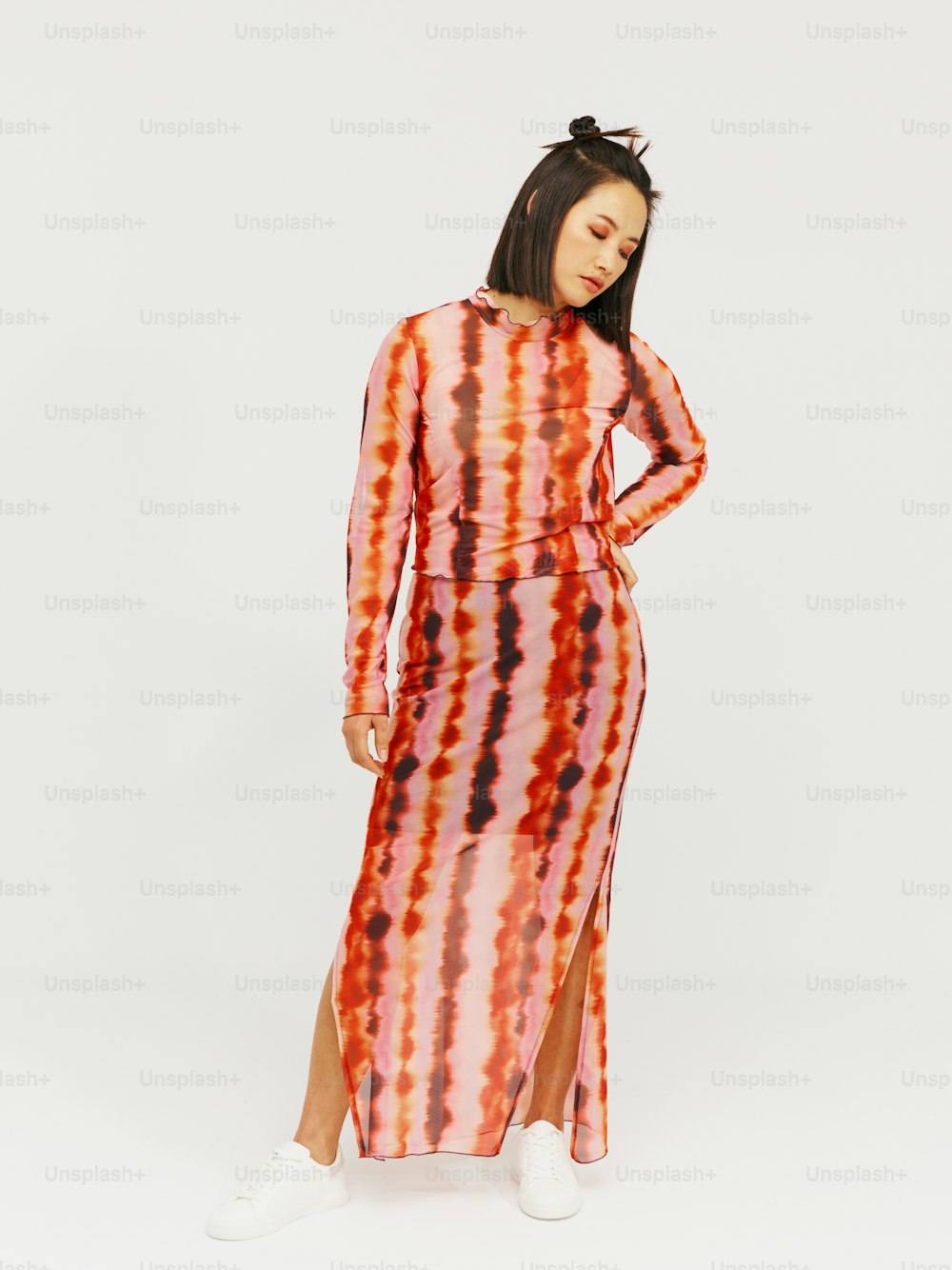 a woman wearing a long dress with a tie dye pattern