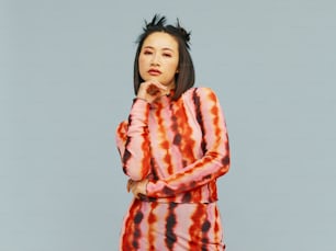a woman in a tie dye dress poses for a picture