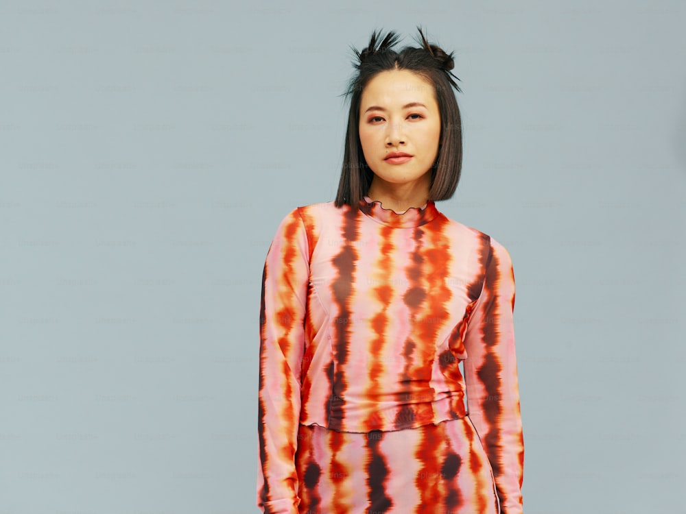 a woman in a tie dye dress poses for a picture