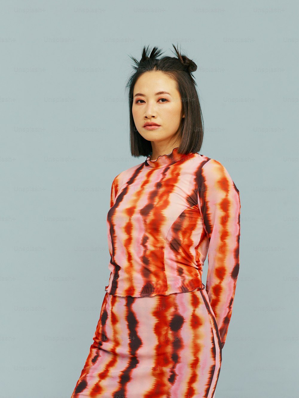 Une femme dans une robe tie dye pose pour une photo