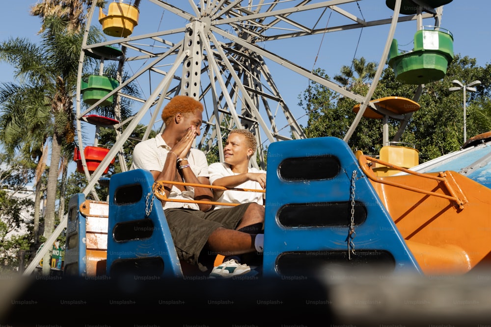 un homme et une femme assis sur un manège de carnaval