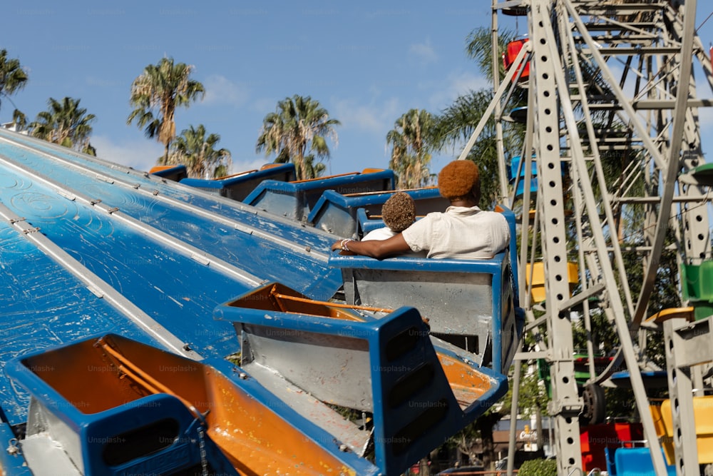 a man riding on the back of a blue roller coaster