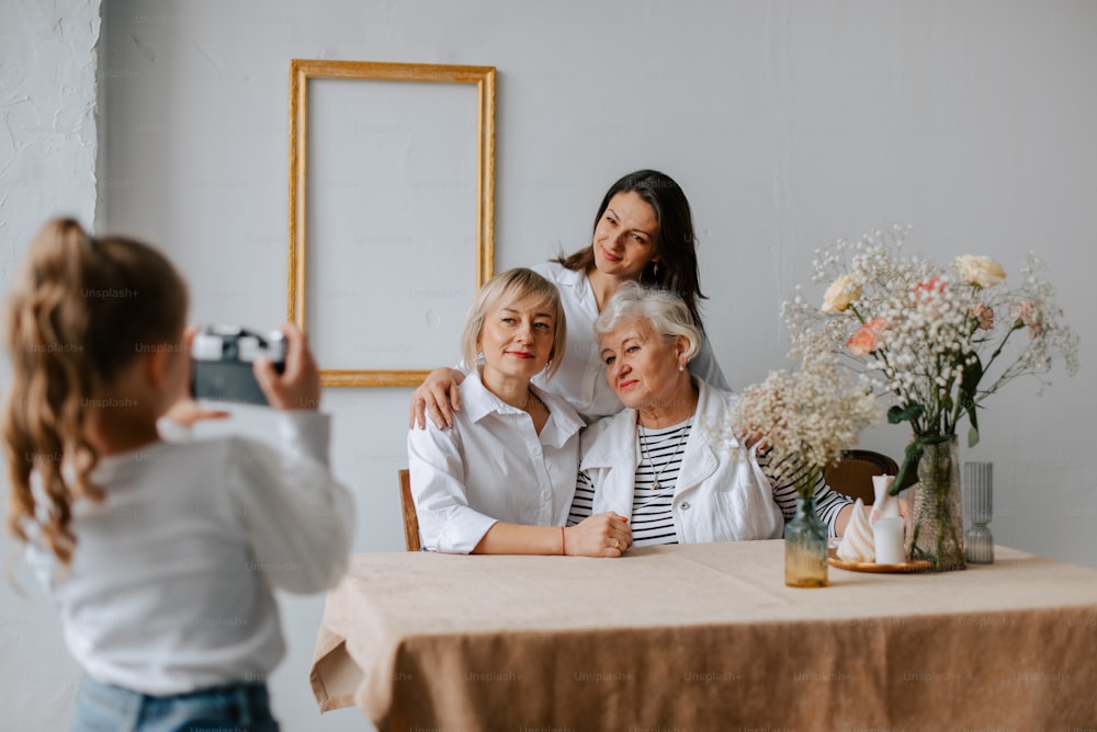 una mujer tomando una foto de dos mujeres mayores sentadas en una mesa