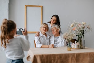 a woman taking a picture of two older women sitting at a table