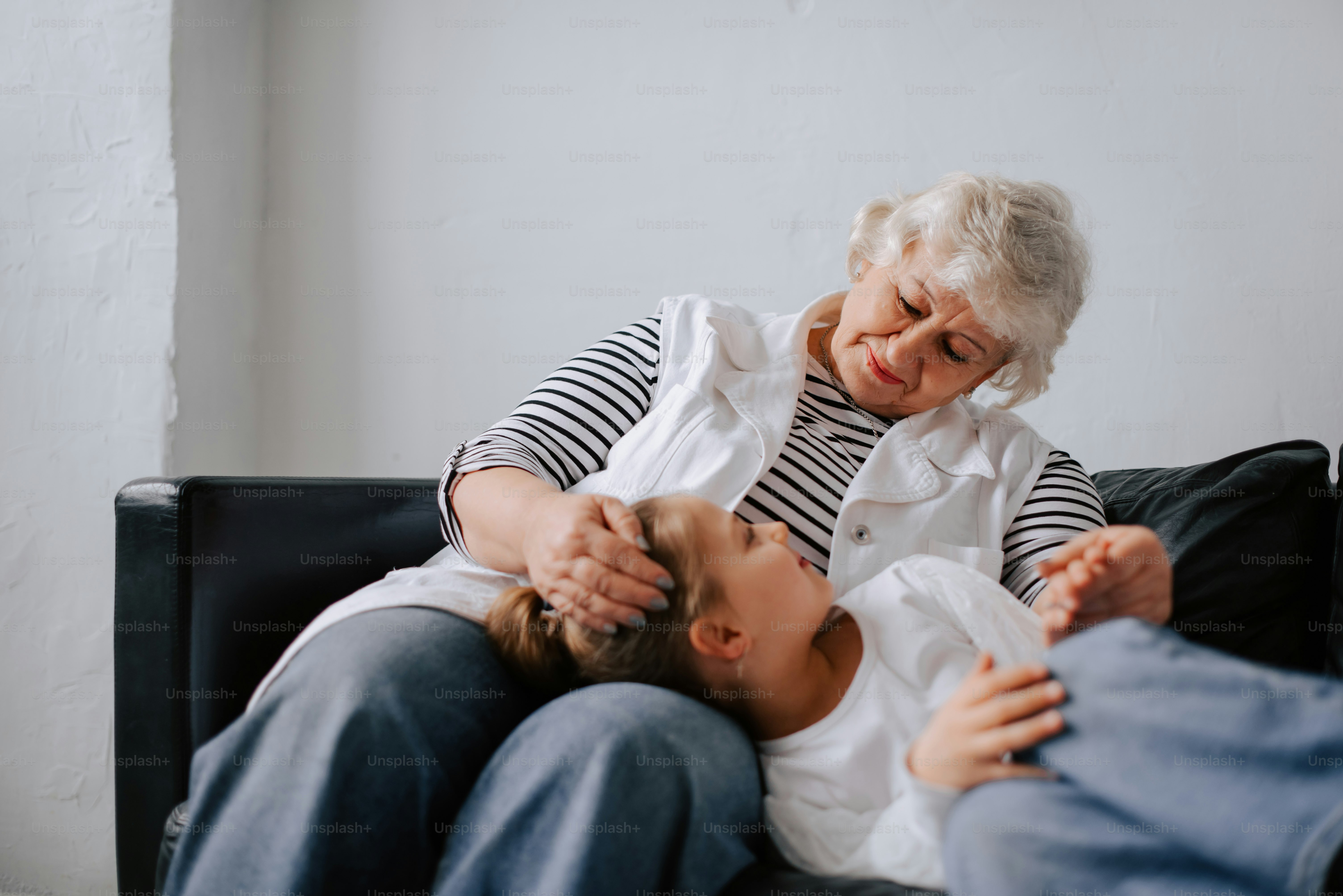 eine Frau, die neben einem Kind auf einer Couch sitzt