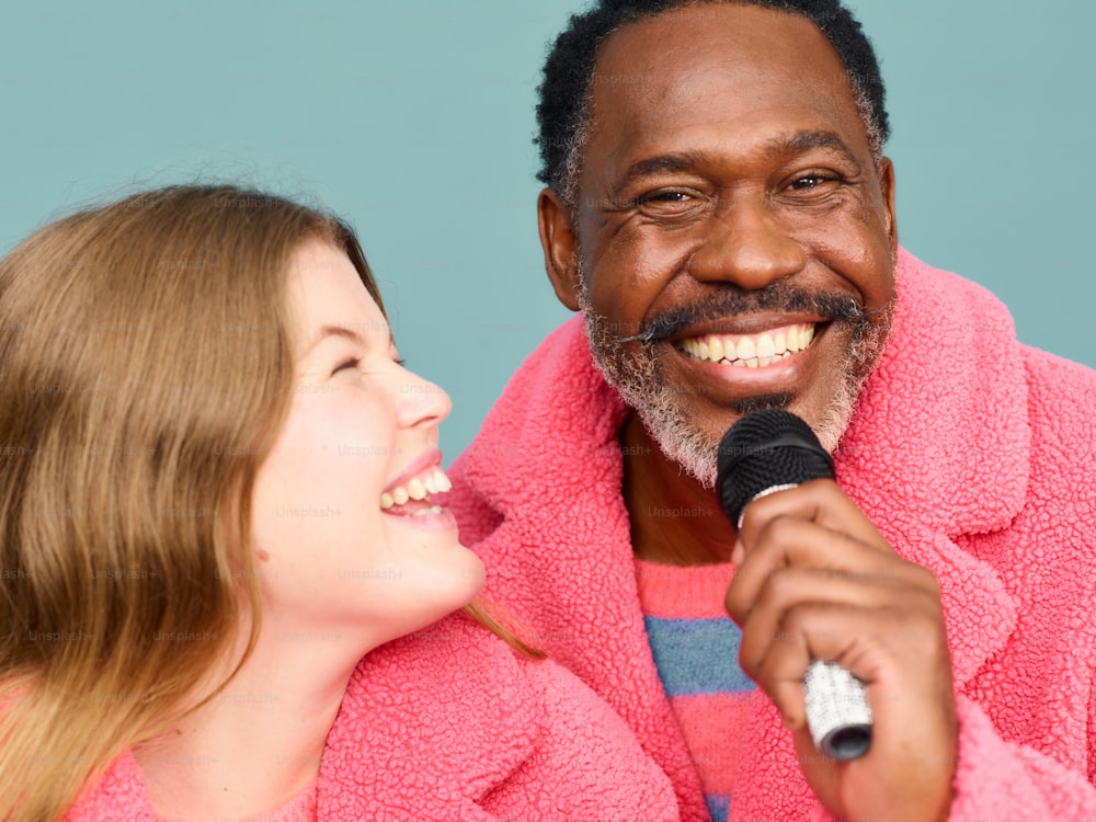 un uomo in una veste rosa che tiene in mano un microfono