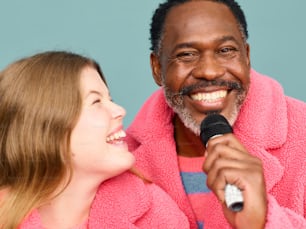a man in a pink robe holding a microphone
