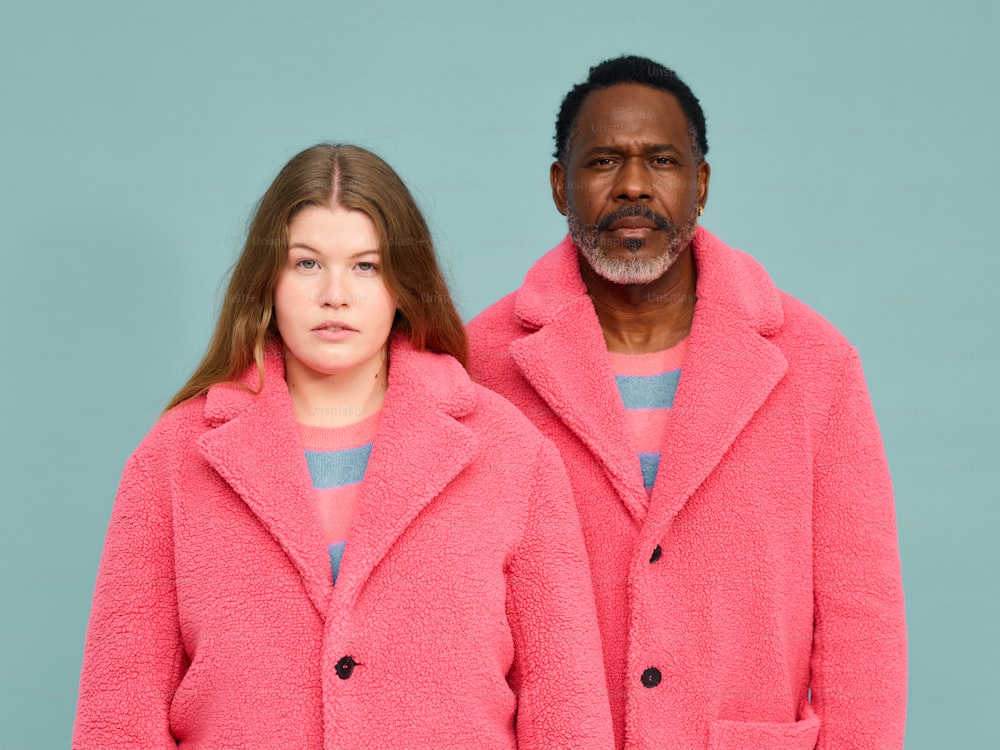 um homem e uma mulher de casacos cor-de-rosa