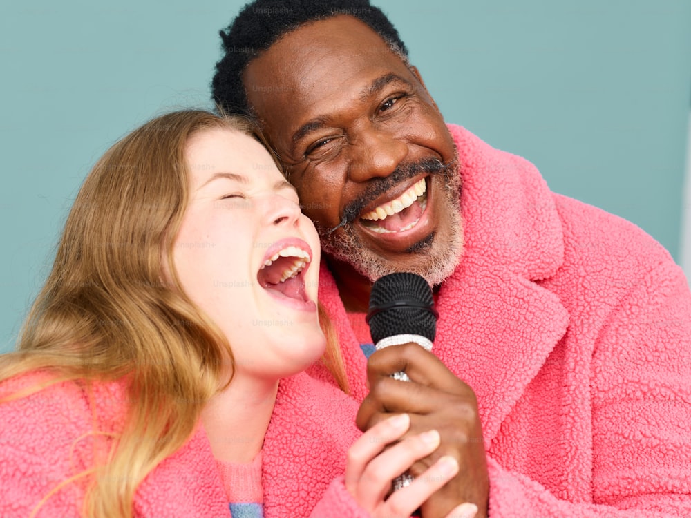 un hombre y una mujer cantando en un micrófono