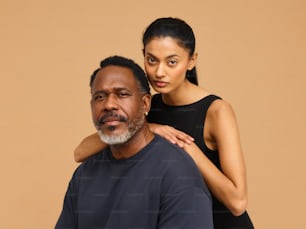 a woman standing next to a man in a black shirt