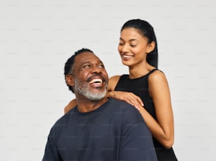 a woman smiles as a man holds his arm around him