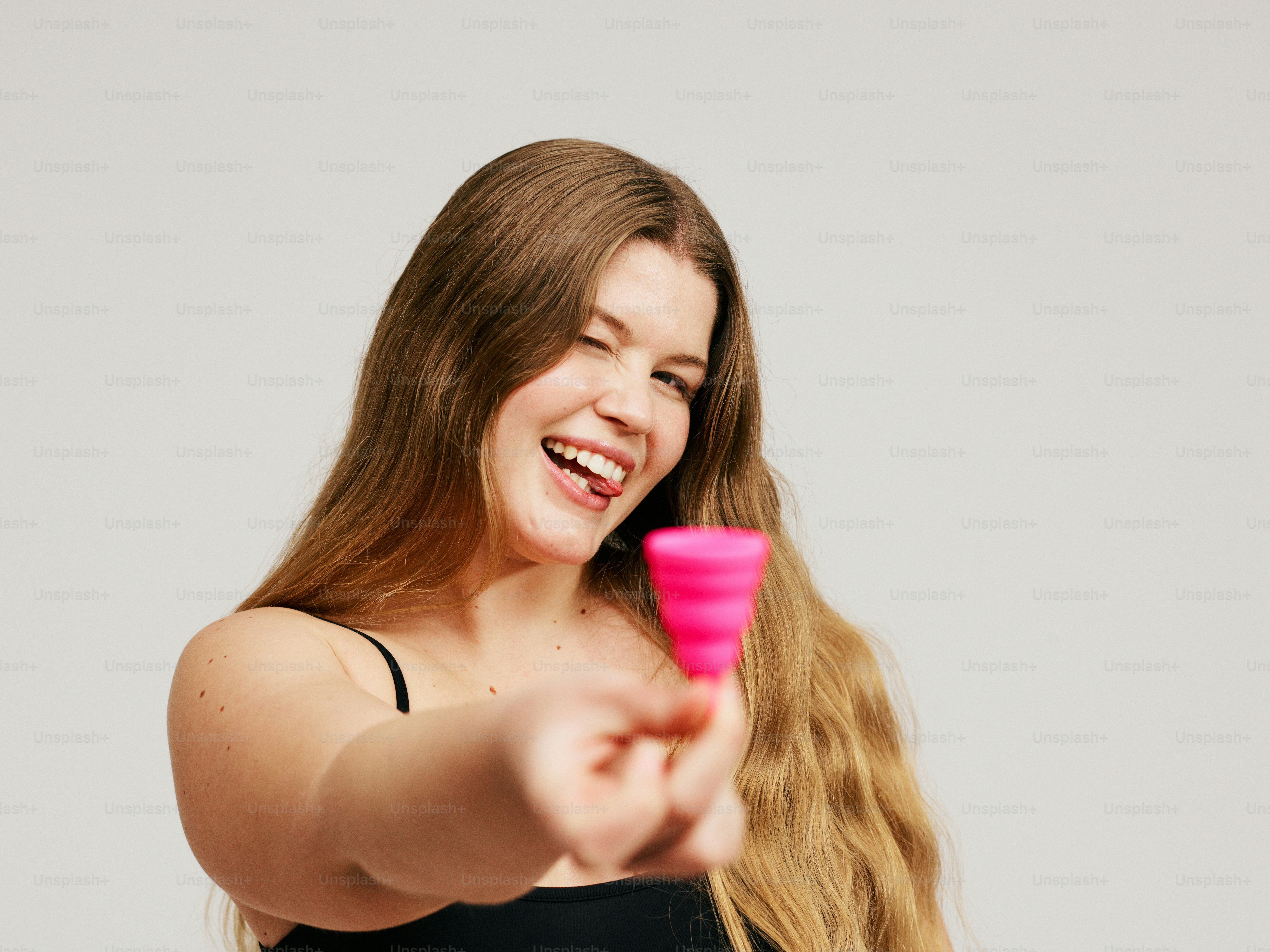 una donna che tiene un oggetto rosa nella mano destra
