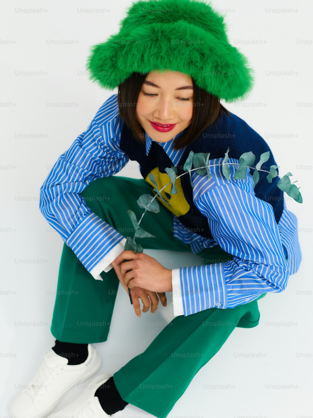 uma mulher usando um chapéu verde e calças verdes