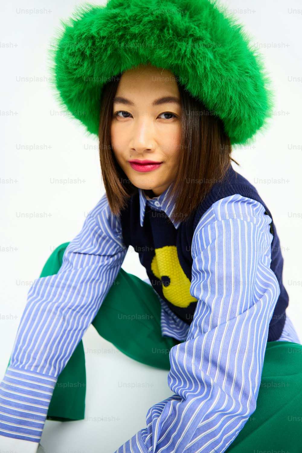 uma mulher usando um chapéu verde e camisa listrada