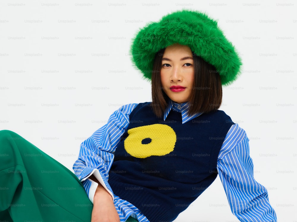 una donna che indossa un cappello verde e un maglione