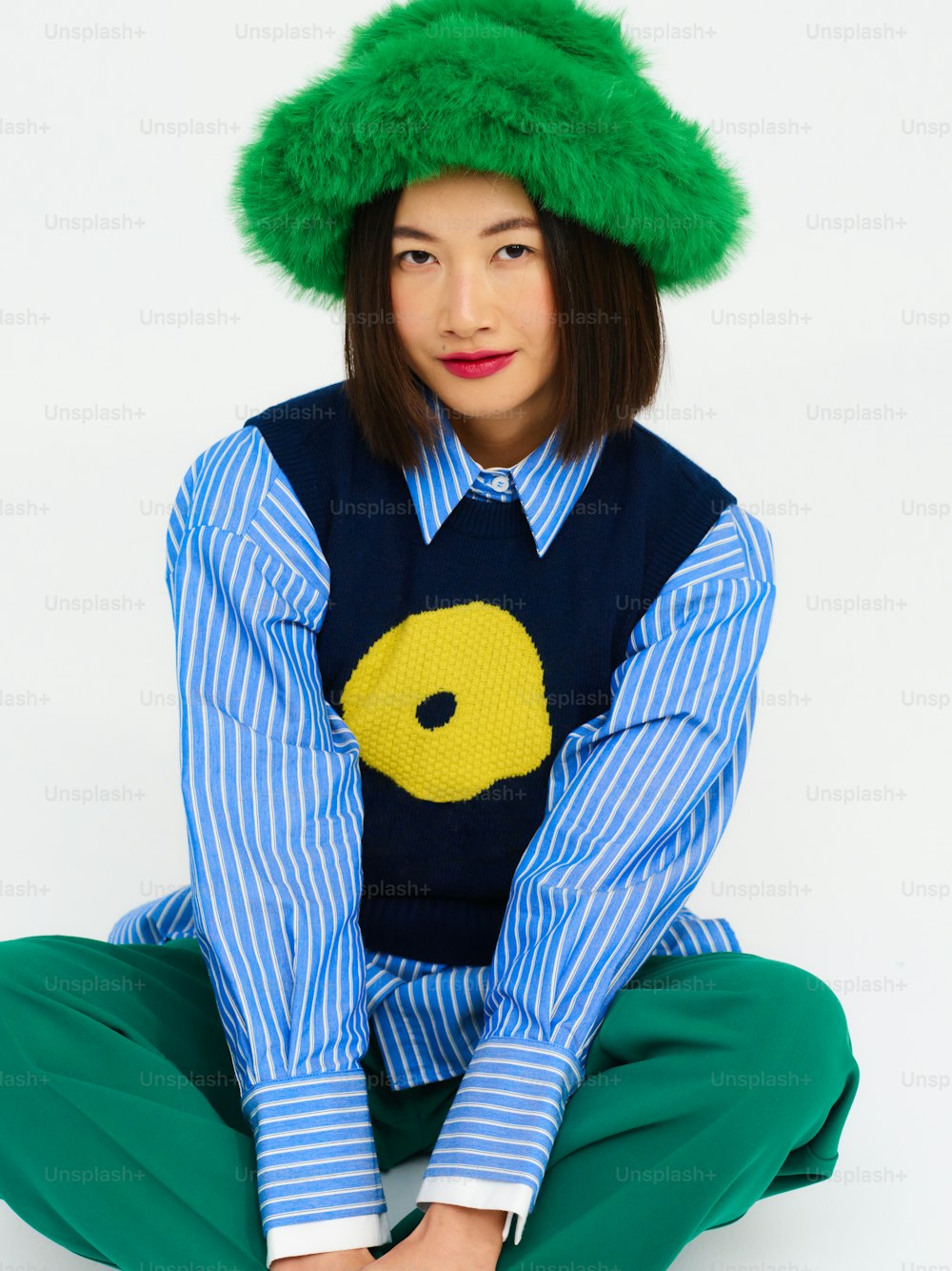 uma mulher usando um chapéu verde e uma camisa azul
