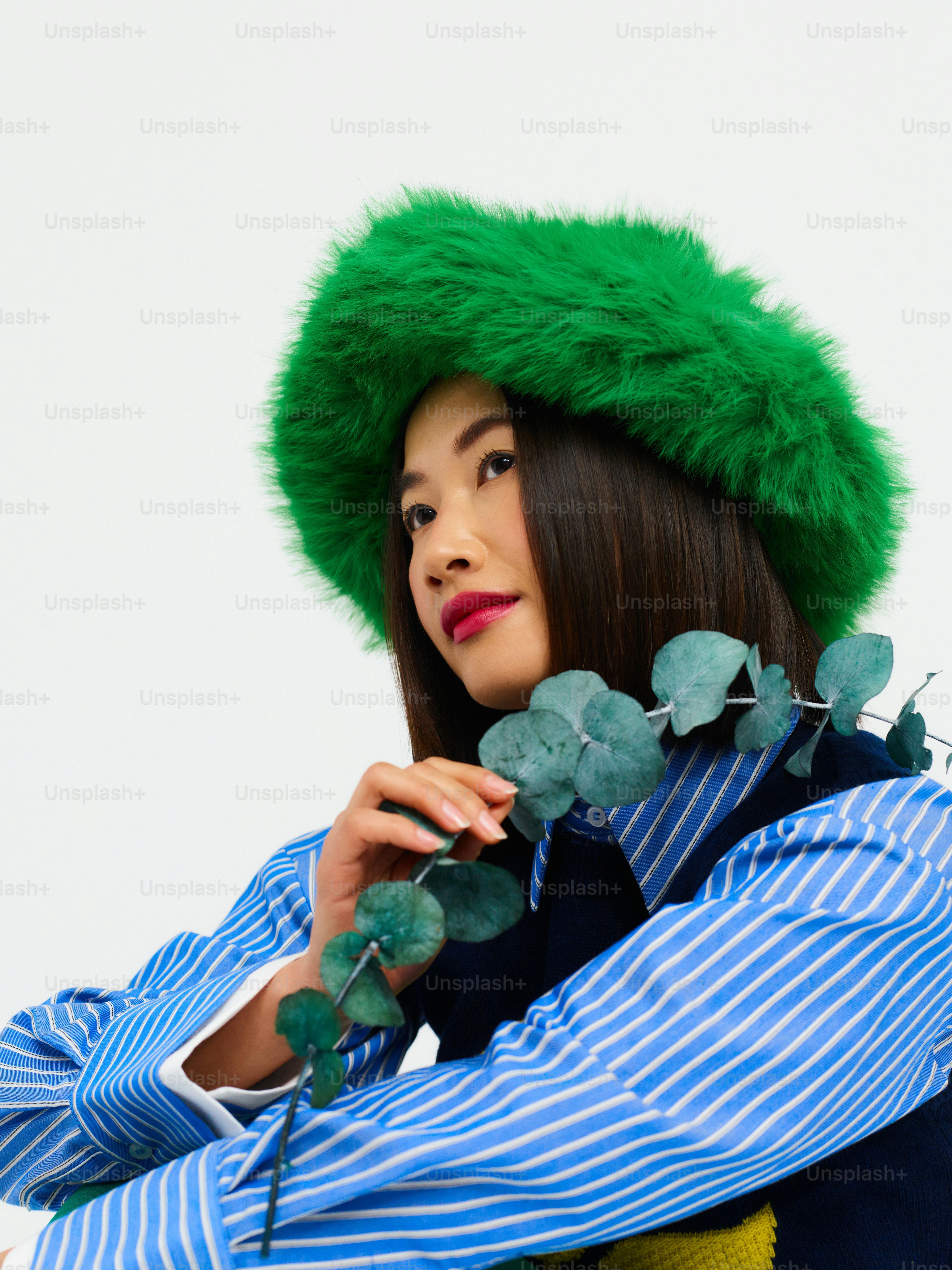 une femme portant un chapeau vert et une chemise rayée
