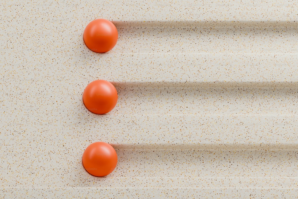 tres bolas naranjas colocadas sobre una superficie blanca