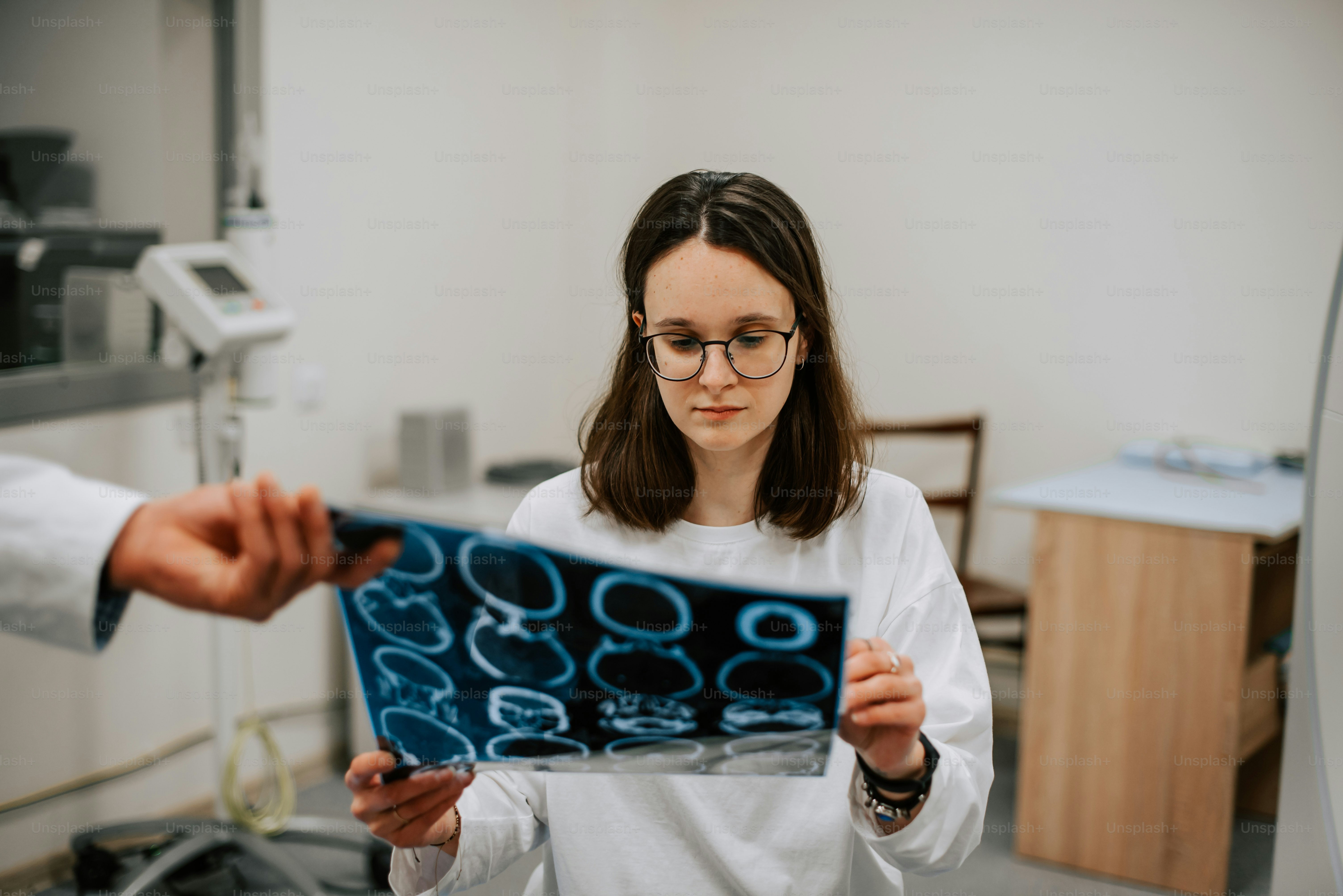 Eine Frau in einem weißen Hemd hält eine blaue Schachtel in der Hand