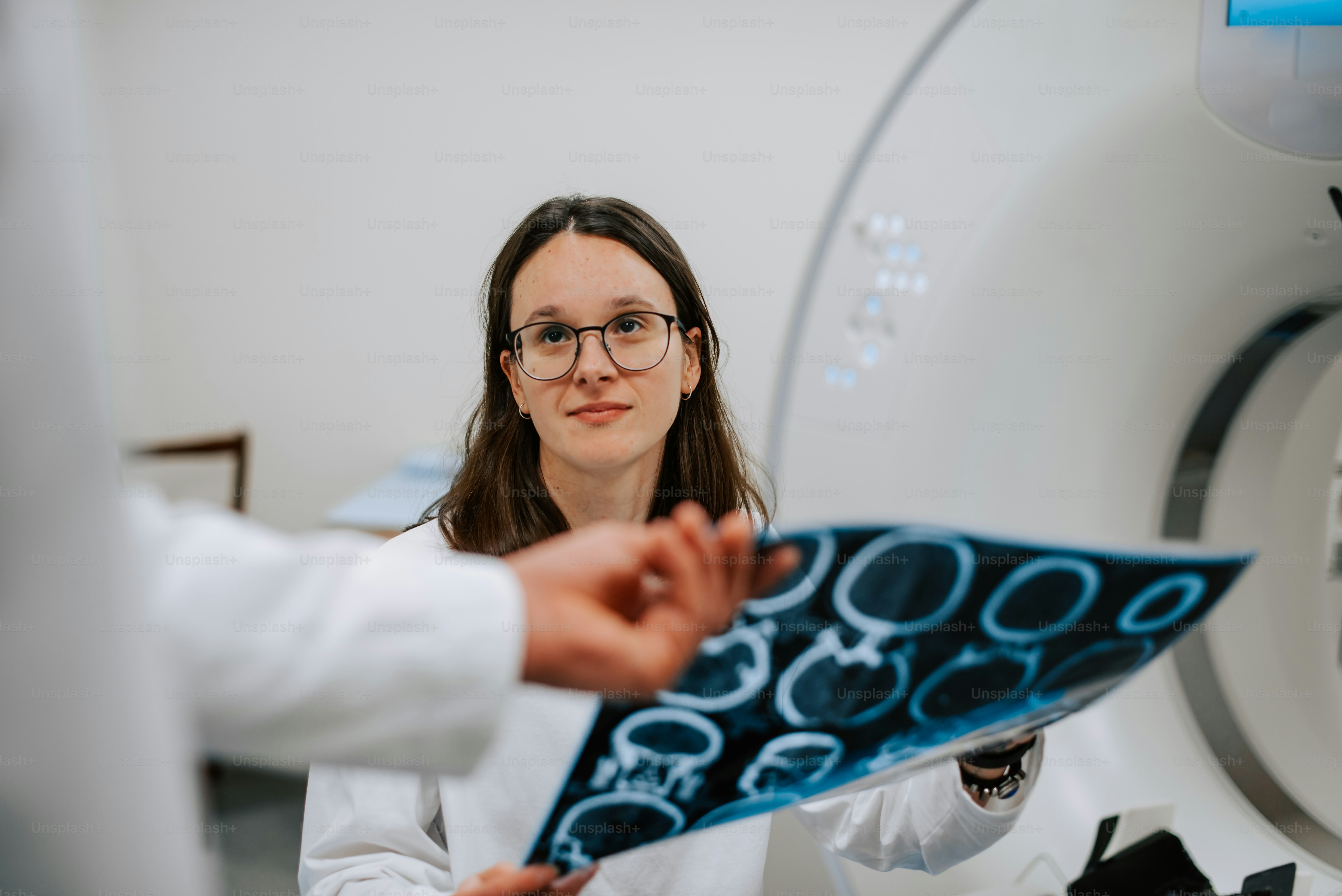 a woman in a white lab coat holding a blue object