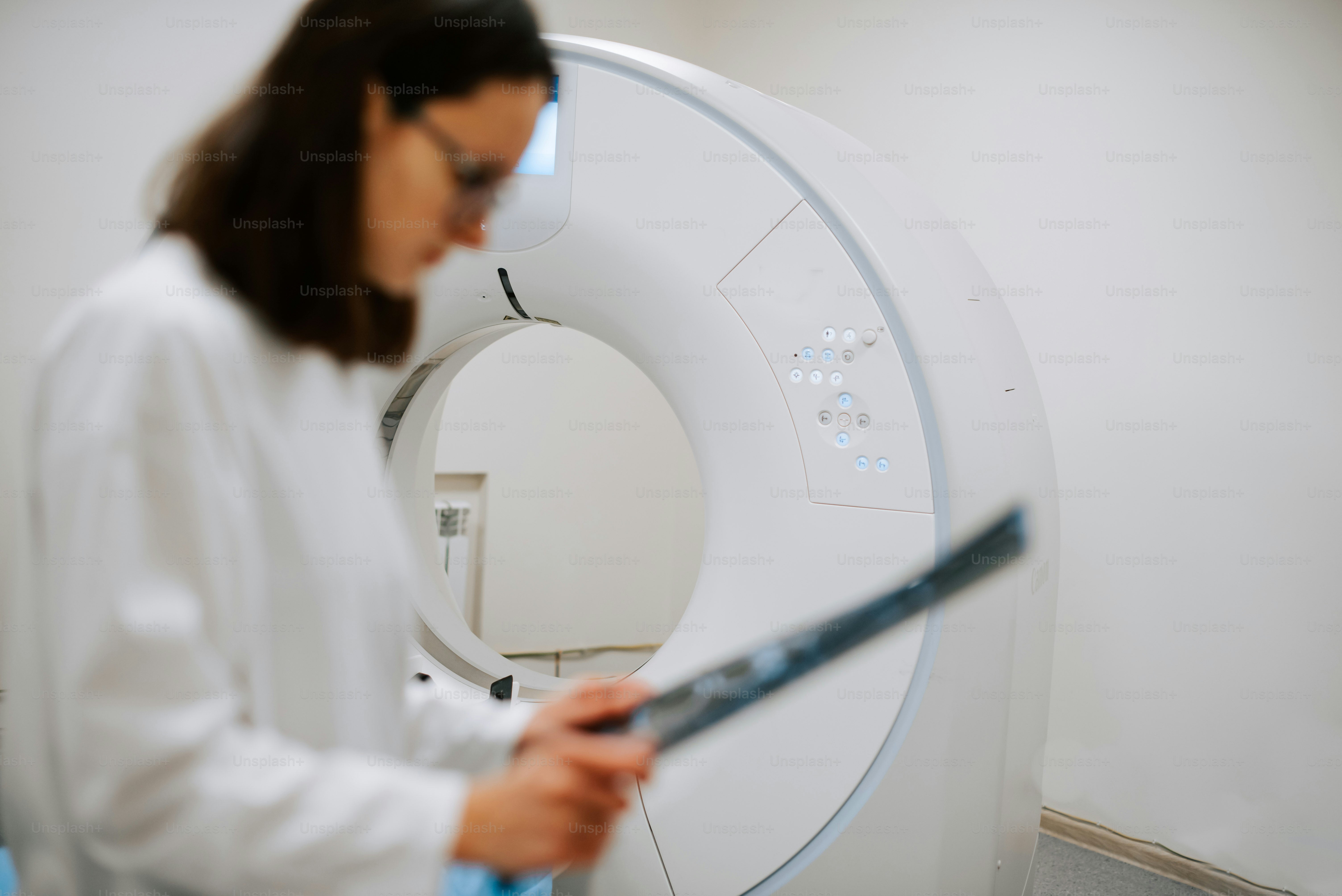 Eine Frau in einem weißen Laborkittel hält einen großen Gegenstand in der Hand