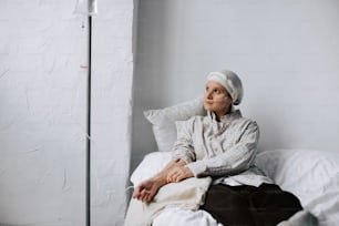 a woman sitting on top of a bed next to a lamp