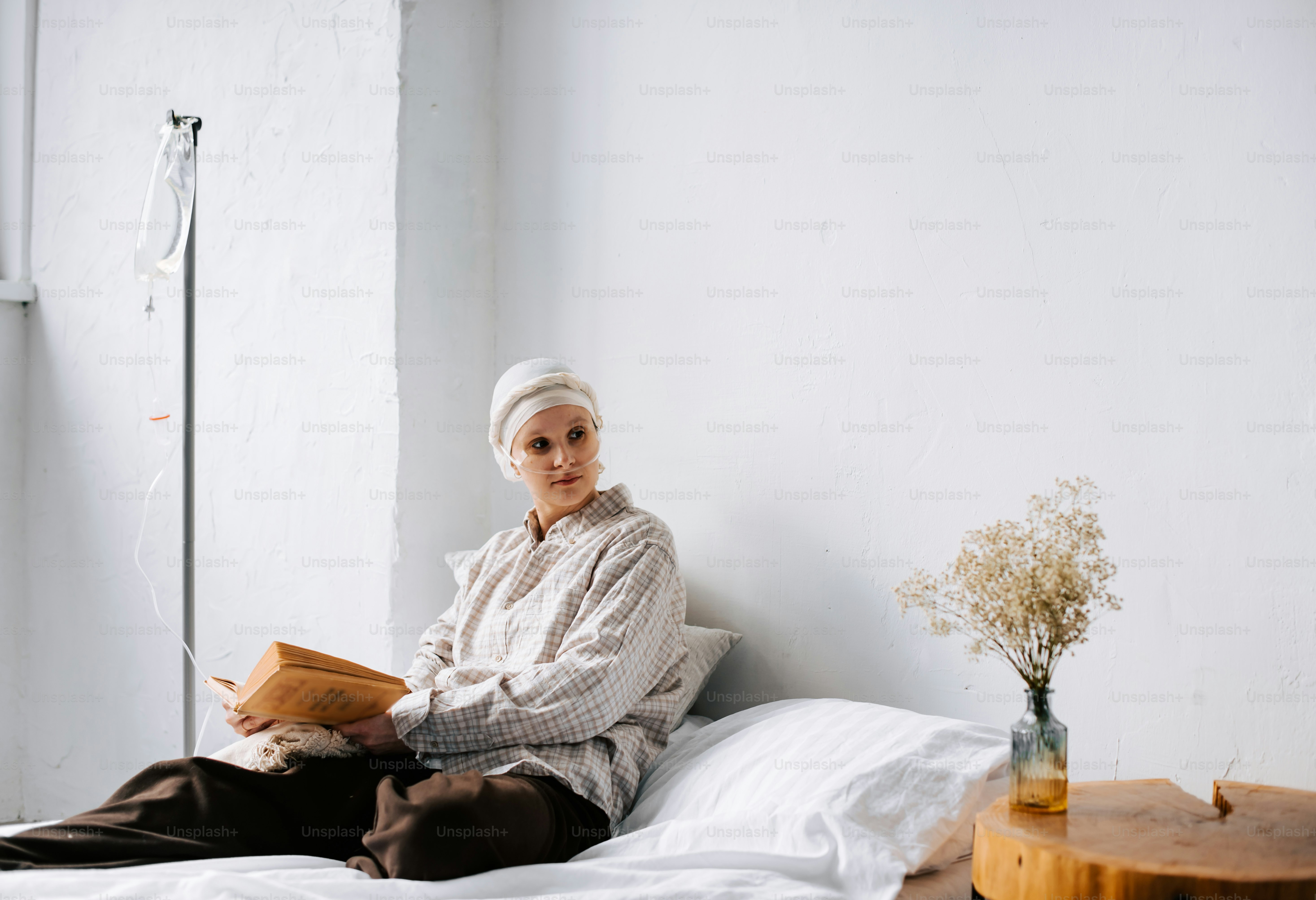 a woman sitting on top of a bed holding a book