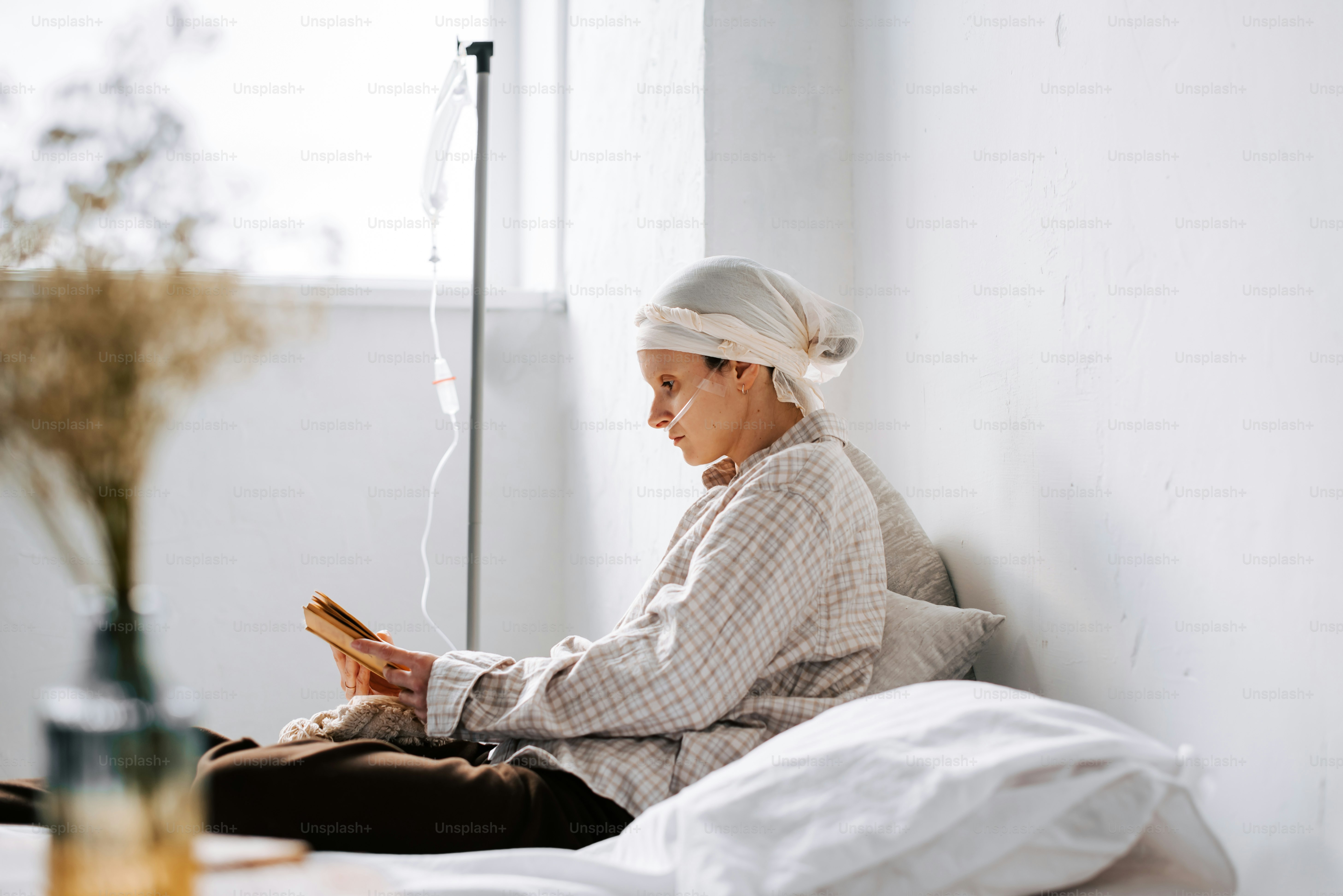 a woman sitting on a bed reading a book
