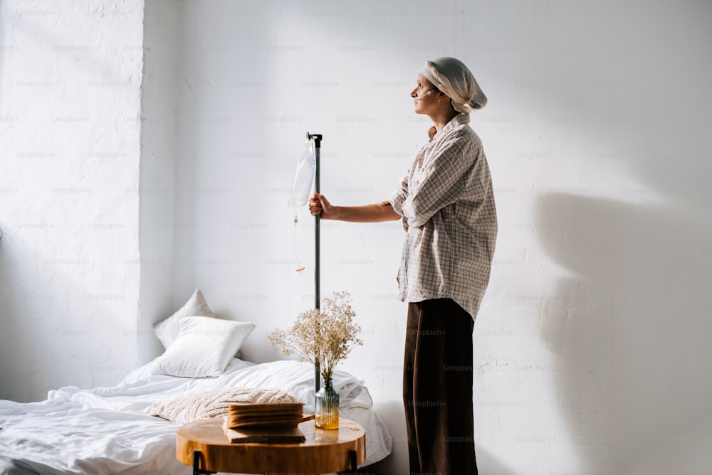 a woman standing next to a bed holding a broom