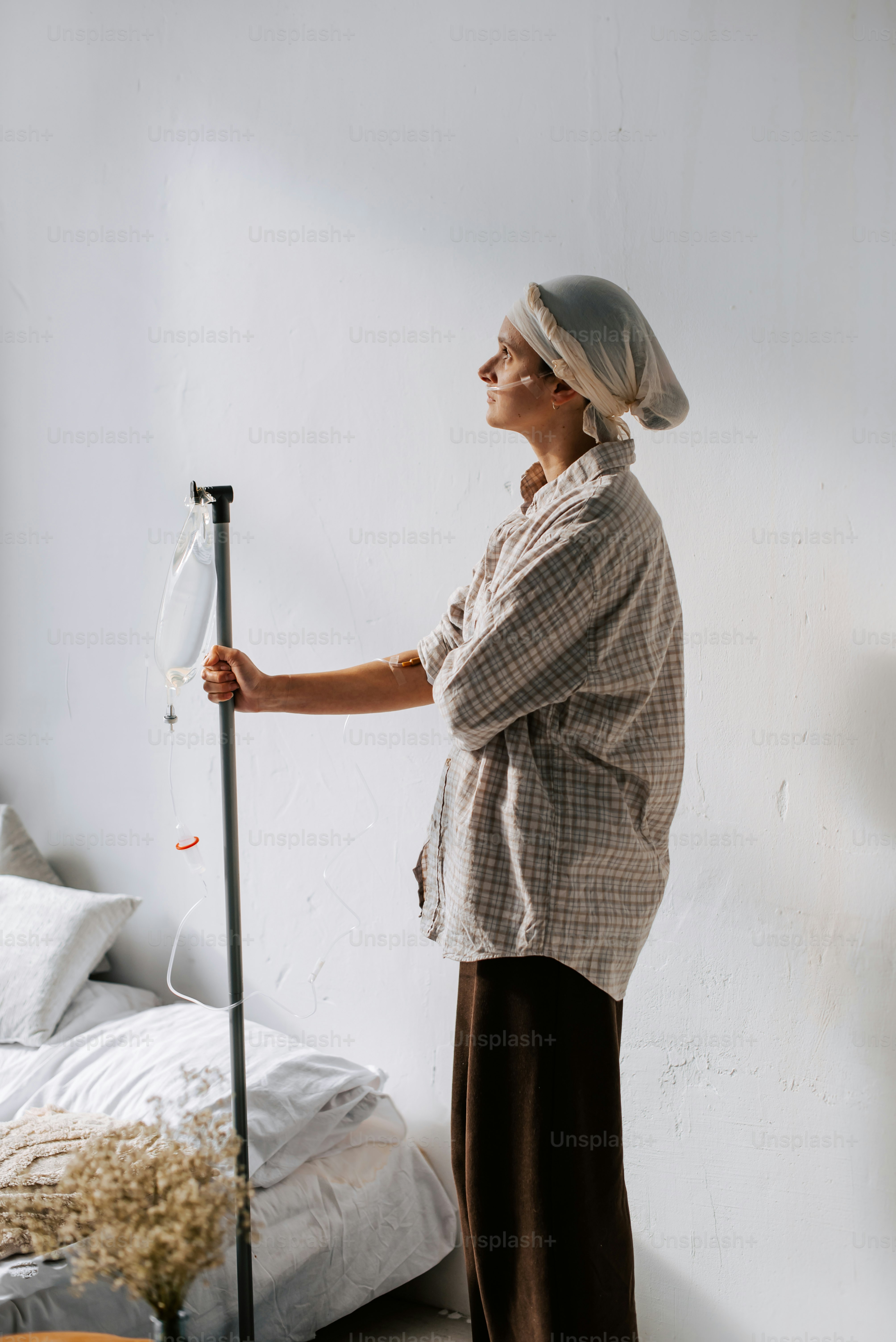 a woman standing next to a bed holding a broom