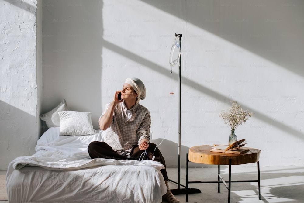 a person sitting on a bed talking on a cell phone