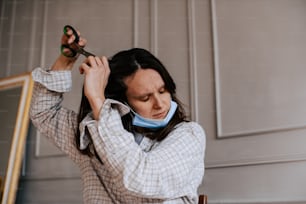 a woman wearing a neck gaiter holding a bottle of wine