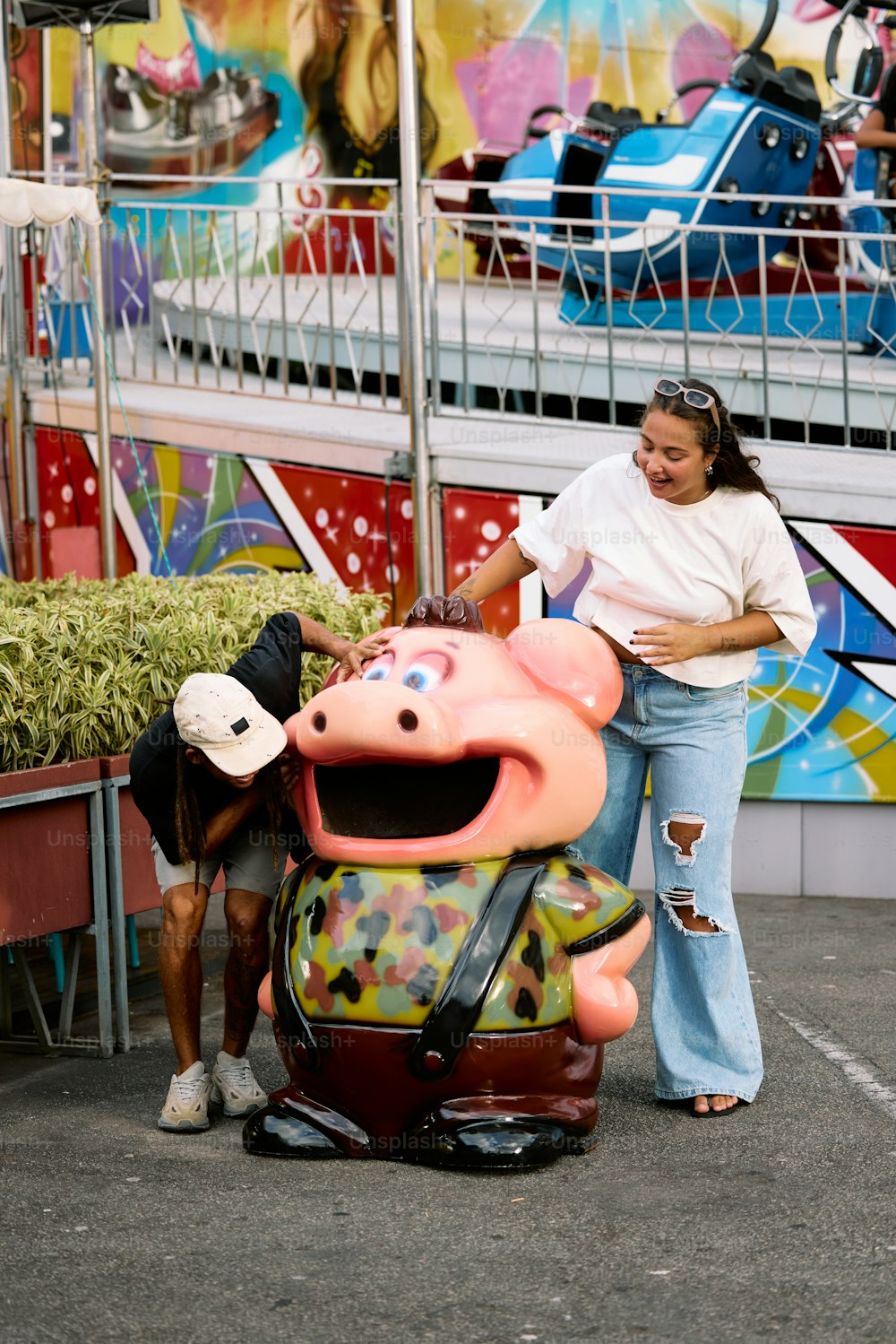 a woman standing next to a statue of a pig