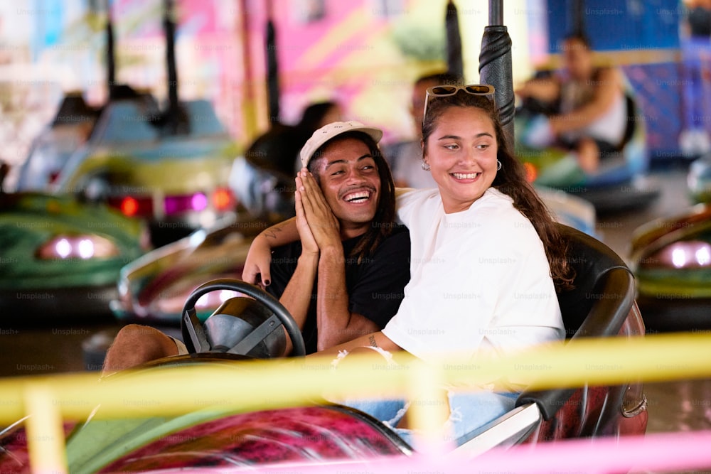 a man and a woman riding a roller coaster at a carnival