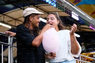 a man standing next to a woman holding a pink balloon