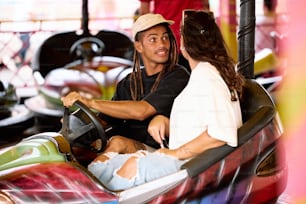 a man and a woman sitting in a bumper car