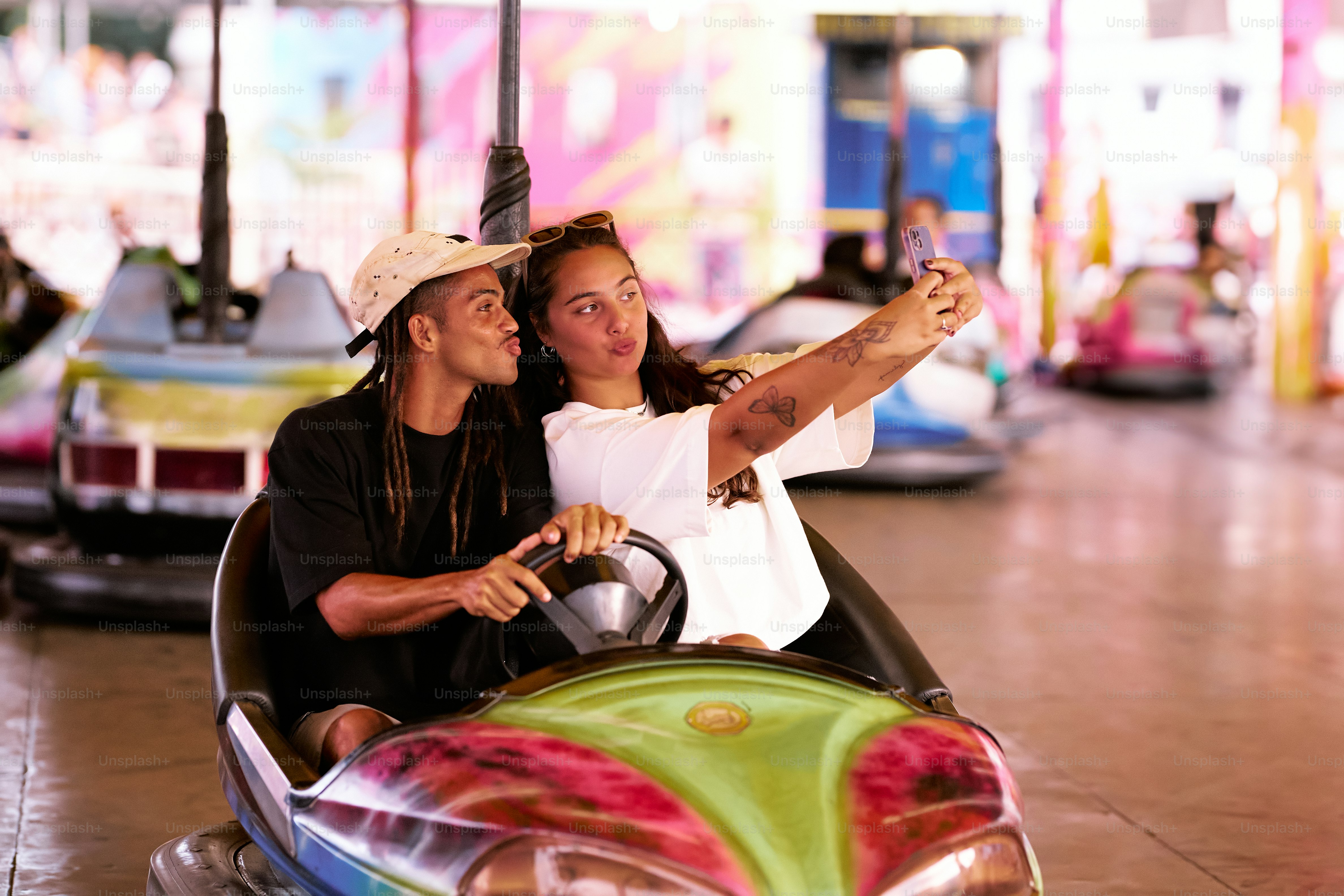 a man and a woman taking a selfie in a bumper car